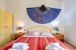 a bedroom with a bed and a large clock on the wall at Villa Rosa Sea View in Valledoria