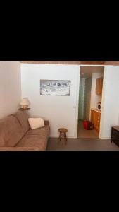 a living room with a couch and a table at Studio pied de piste Pelvoux 2 in Vars