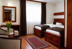 a hotel room with two beds and a mirror at Vila Prezident in Sremski Karlovci