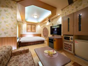 a small room with a bed and a couch and a table at HOTEL WiLL 大高 レジャーホテル in Nagoya