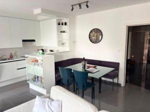 a kitchen and dining room with a table and blue chairs at Appartemment familial à Westende in Westende-Bad