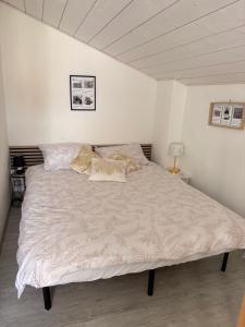a bedroom with a large bed with white sheets and pillows at Maisonnette Oléron à 30 mètres de la plage 3 étoiles in Saint-Denis-dʼOléron