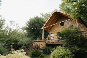 a house with a large deck in the woods at ZenZug, a vendégház in PerÅ‘csÃ©ny