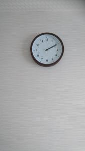 a black and white clock hanging on a wall at Terminal Hotel Matsuyama in Matsuyama
