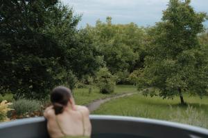 a woman in a vehicle looking out at a garden at ZenZug, a vendégház in PerÅ‘csÃ©ny +25 photos