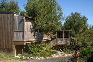 a house with two decks and a tree at Villa Occitana in Calvisson