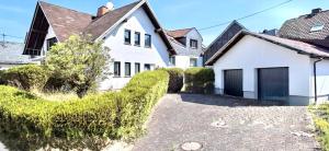 a white house with a black roof and a driveway at Whirlpool Kamin Sauna Herthasee in Eppenrod