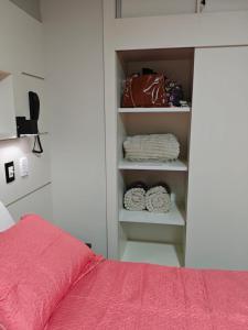 a bedroom with a bed with a red blanket and a closet at Flat 113, Hotel Cavalinho Branco in Águas de Lindoia +17 photos