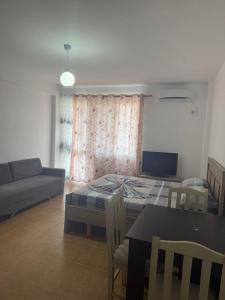a living room with a bed and a table and a couch at Shëngjin Beach Nest in Lezhë