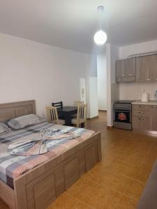 a bedroom with a large bed and a kitchen at Shëngjin Beach Nest in Lezhë