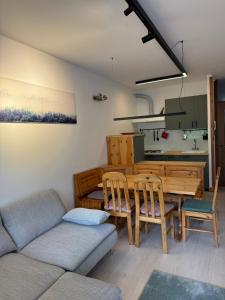 a living room with a table and a couch at Tra Neve e Lago Mountain Apartment in Sella Nevea