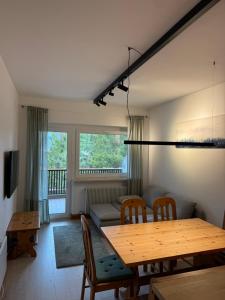 a living room with a wooden table and chairs at Tra Neve e Lago Mountain Apartment in Sella Nevea