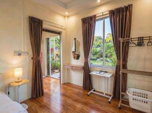 a bedroom with a bed and a large window at Casa Srithanu in Ko Phangan