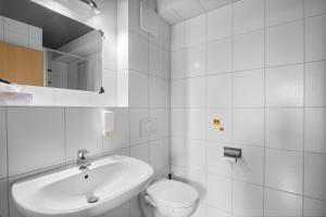a white bathroom with a sink and a toilet at Gästehaus am Wasserpark in Rust +42 photos