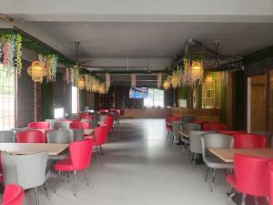 a dining room with tables and red chairs at Golden Heights in Dehradun