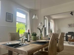 a dining room with a wooden table and chairs at Ferienwohnung M2 in Husby