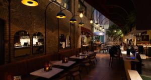 a restaurant with tables and chairs and a brick wall at City Hotel Gouda, WorldHotels Crafted in Gouda
