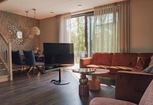 a living room with a couch and a television at Parc La Dune Marrakesh Lodge in Warmenhuizen