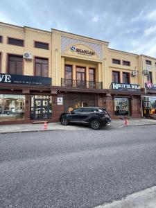 a black car parked in front of a building at Shahzam Hotel in Samarkand