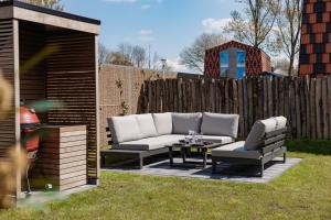 a backyard with a couch and chairs and a table at Parc La Dune Marrakesh Lodge in Warmenhuizen