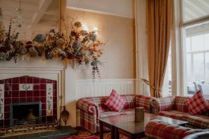 a living room with couches and a fireplace at The Atholl Palace in Pitlochry +144 photos
