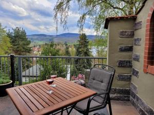 a wooden table with two glasses of wine on a balcony at Ferienhaus Rasselbock in Waltershausen