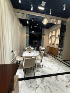 a dining room with tables and chairs on a marble floor at Shahzam Hotel in Samarkand