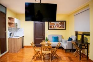 a living room with a table and a kitchen at Posada Miraflores in Lima