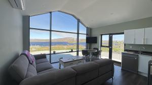 a living room with a couch and a large window at Calla Retreat in Roundstone