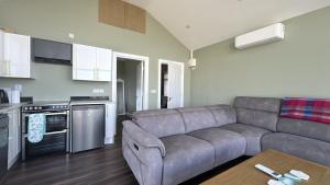 a living room with a couch and a kitchen at Calla Retreat in Roundstone