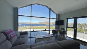 a living room with a couch and a large window at Calla Retreat in Roundstone +10 photos