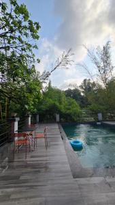 a pool with two chairs and a table and a blue raft at Amazinn Hotel in Lonavala