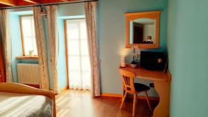 a bedroom with a desk with a computer and a mirror at Chalet Dolomiti Trentino in Sant’Orsola