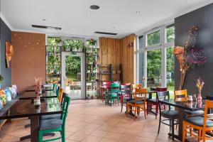 a restaurant with tables and chairs and windows at Gästehaus am Wasserpark in Rust
