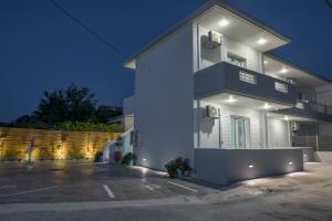 a white house with a parking lot in front of it at Diana's Houses in Gythio