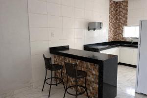 a kitchen with two chairs and a counter in a kitchen at Casa para temporada em SRN in São Raimundo Nonato