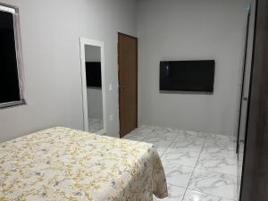 a bedroom with a bed and a flat screen tv at Casa para temporada em SRN in São Raimundo Nonato