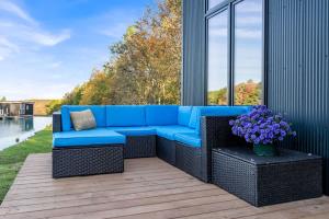 Ein blaues Sofa steht auf einer Terrasse mit Blumen. in der Unterkunft Tiny House on a Waterfall at Private Tiny Lake in Brackney
