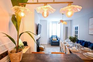 a dining room with a table with a plant and lights at Kent House in Ramsgate