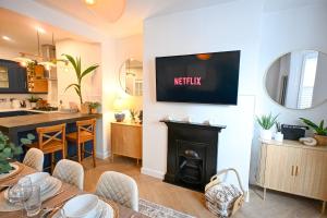 a kitchen and living room with a fireplace and a table at Kent House in Ramsgate