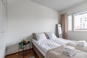 a white bedroom with a bed and a window at Central Studio I by Elys Collection in Rovaniemi