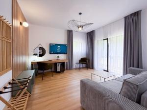 a living room with a couch and a desk at Hotel TISA in Băile Olăneşti