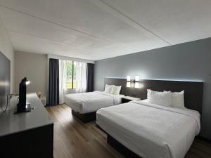 a hotel room with two beds and a television at SureStay by Best Western Charlotte Matthews in Matthews