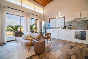 a kitchen and living room with a couch and a table at Aruna Resort & Villas in San Pedro