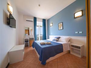 a bedroom with a bed with a blue wall at Hotel Club Perla in Casalabate +55 photos