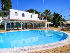 a large swimming pool in front of a white building at Hotel Club Perla in Casalabate