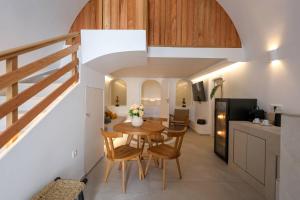 a kitchen and dining room with a table and chairs at Dagaz Suites in Fira