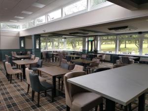 a restaurant with tables and chairs and windows at Beamish Lodge in Stanley