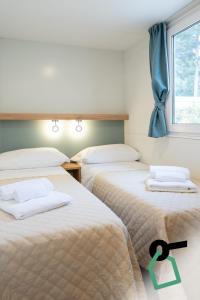two beds in a room with a window at Hotiday Otranto Porto in Otranto