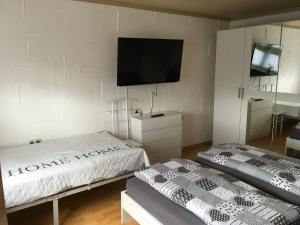 Zwei Betten in einem Zimmer mit einem Fernseher an der Wand. in der Unterkunft FeWo Eberau in Ebrach